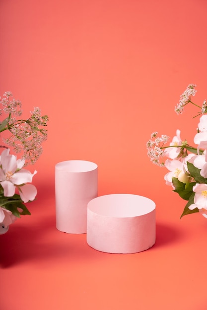 Natural minimal beauty pedestal empty cosmetics podiums on pink background with flowers for product