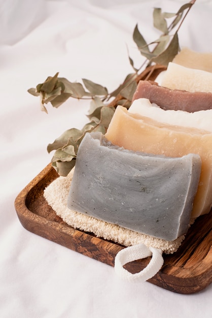 Natural organic cosmetics. Stack of hand made soap in wooden tray on white background