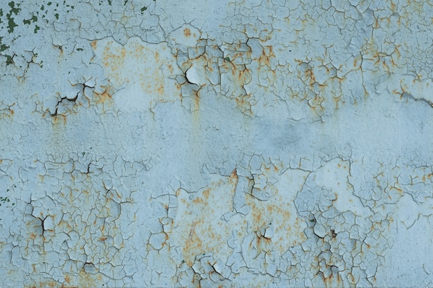 Natural pattern of peeling paint on a metal surface.