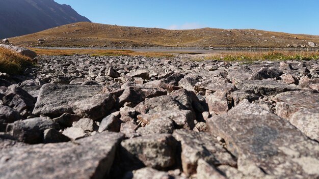 Natural paving stones made of stones in the mountains. The trail leads to a moraine lake.