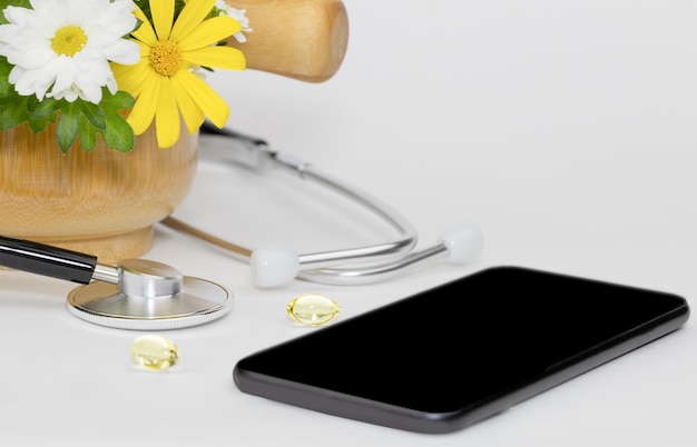 Natural pills and stethoscope on white background Taraxacum