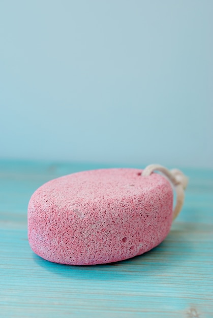 Natural pumice stone with white rope on wood.