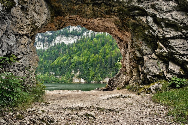 A natural rock gate wih a lake and forest in the background