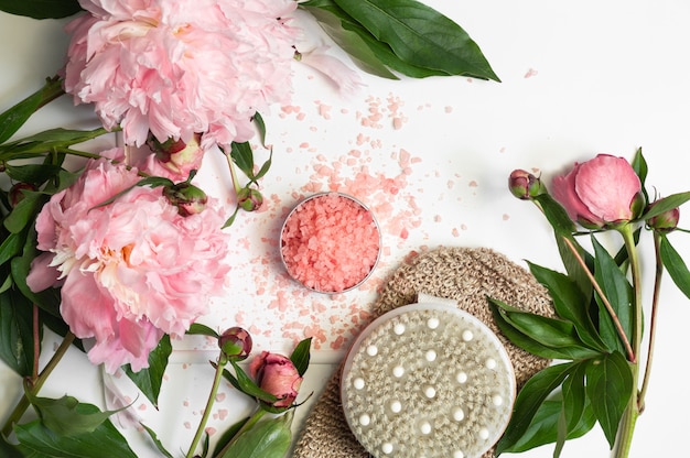 Natural salt for bath with dry massage brush and peony flowers