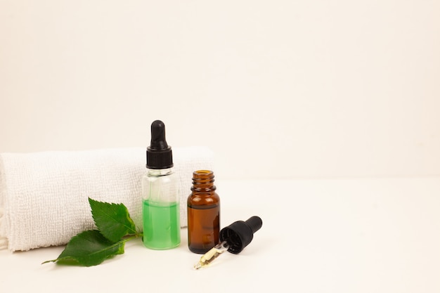 Natural skincare bottle container and organic green leaf on white background