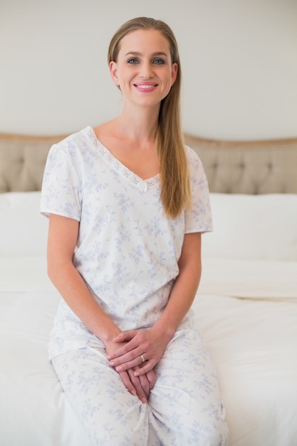 Natural smiling woman sitting on bed