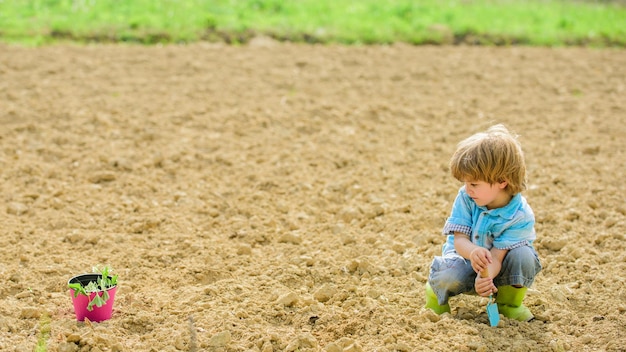 Natural soil new technology in farming small kid planting a flower ecology life eco farm human and nature earth day copy space summer farm happy child gardener botanic worker Spring