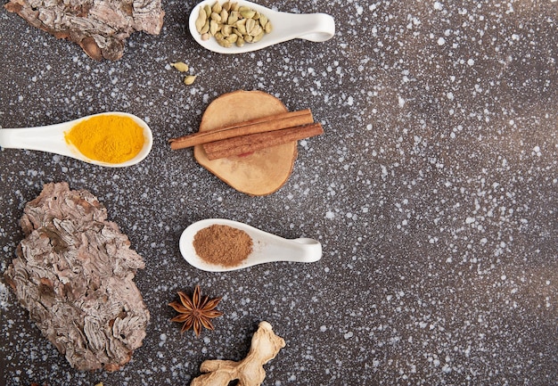 Photo natural spices of turmeric cardamom cinnamon dried ginger star anise with copy space condiments on black background