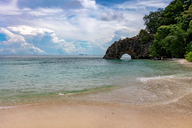 Natural stone arch against sunbeam and blue sky at Kho Khai near Tarutao national park and Koh Lipe in Satun Thailand