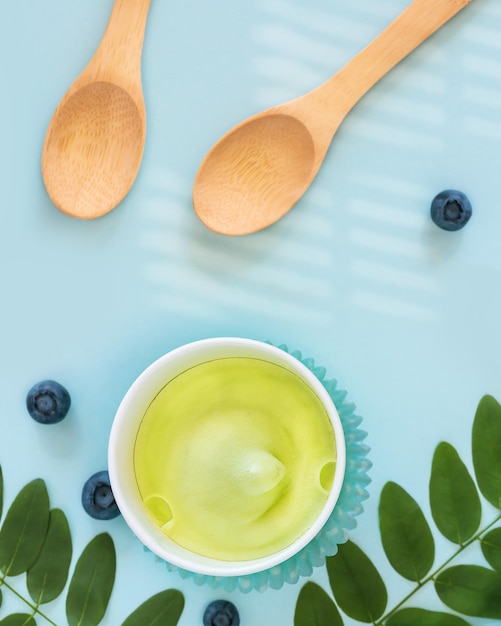 Natural vegan ice cream blueberries leaves and wooden spoons on a blue background