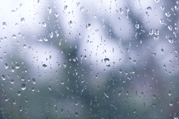 Natural water drops on window Small medium and large droplets on grey glass Flowing raindrops Rainy day