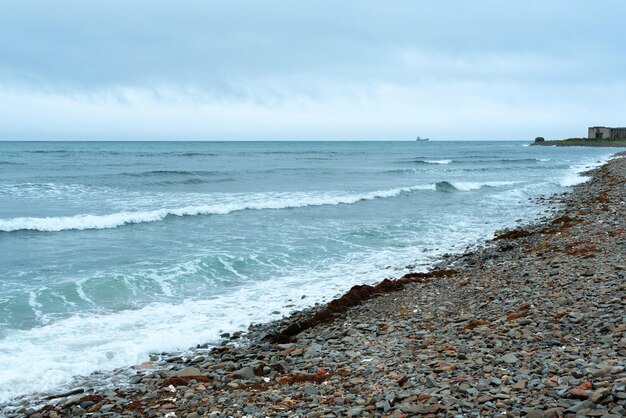 Nature background with sea waves hitting the sea shore Scenic view of sea against cloudy sky