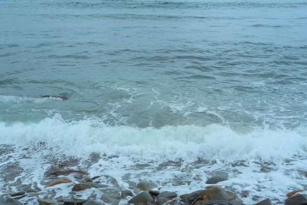 Nature background with sea waves hitting the sea shore Scenic view of sea against cloudy sky