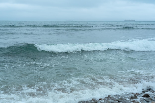 Nature background with sea waves hitting the sea shore Scenic view of sea against cloudy sky