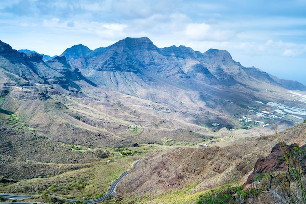 Nature landscape of Canary Island with mountain range, green hills and curvy road