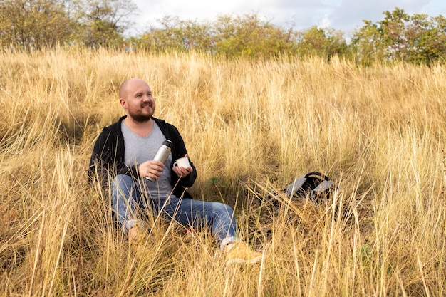 Nature, a man resting on the grass with tea