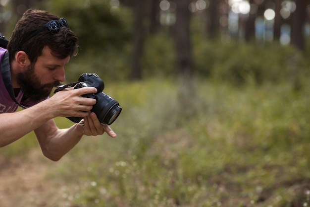 nature photographer. man with camera in the forest. wanderlust and travel lifestyle