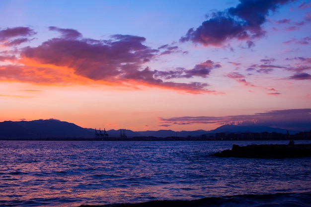 Nature in twilight period on the sea sunset over the mountain Beautiful clouds painted in orange color Nature background