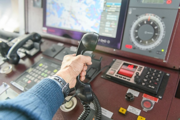 Navigational control panel and VHF radio with hand Radio communication at sea Working on the ship