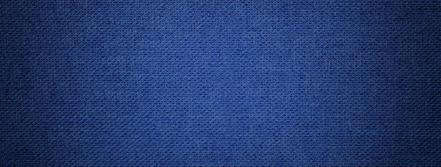 Navy blue background from textile material with wicker pattern and vignette Structure of denim fabric