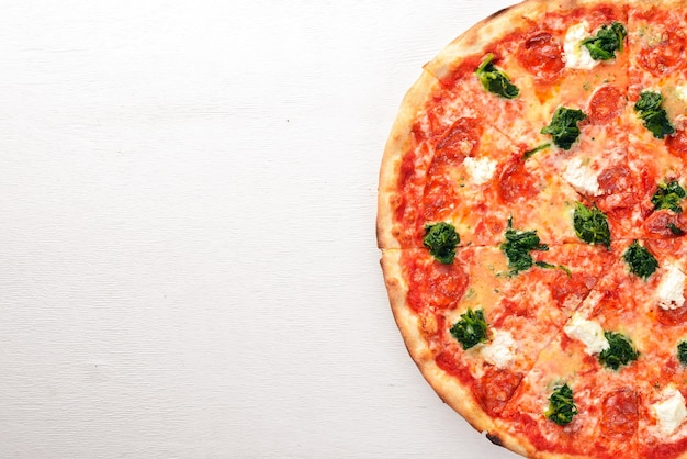 Neapolitan Pizza Spinach gorgonzola cheese sausage salami On a wooden background Top view