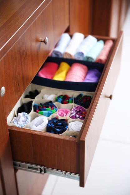 Neatly folded clothes in wooden drawer