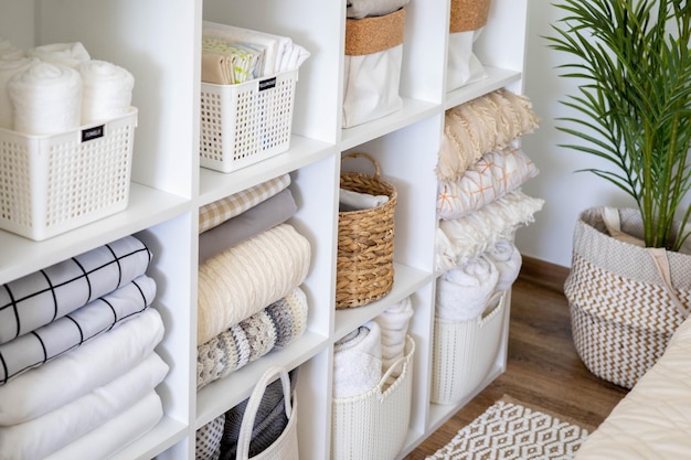 Photo neatly folded linen cupboard shelves storage at eco friendly straw basket placed closet organizer