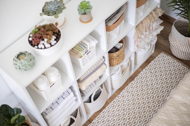 Photo neatly folded linen cupboard shelves storage at eco friendly straw basket placed closet organizer