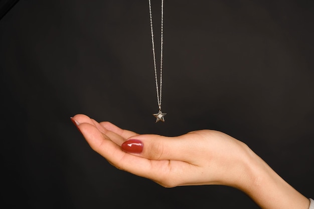 Photo a necklace with a silver star on it is hanging from a chain