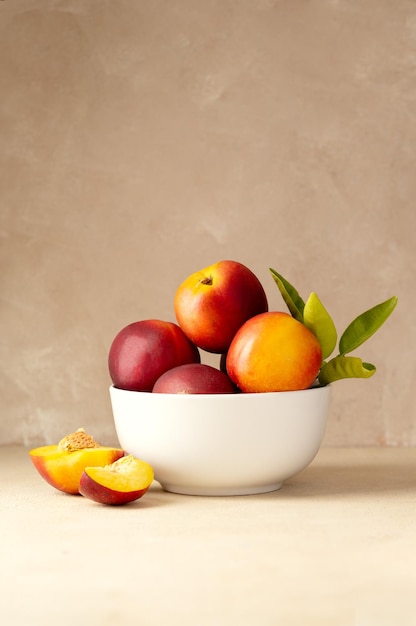 Nectarine peaches fruits in a bowl Neutral background