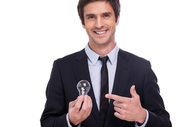 Need some fresh ideas? Handsome young man in formalwear holding light bulb and pointing it