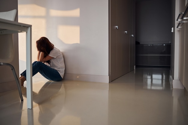 Negative delighted young beauty sitting on the floor