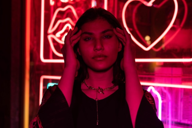 Neon close up portrait of young woman wear hoodie. night city street shot