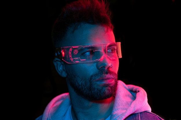 Neon light portrait of serious man model with mustaches and beard in sunglasses and white t-shirt