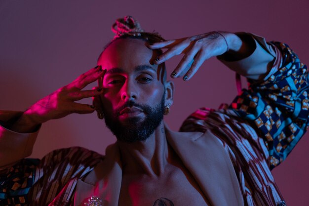 Neon light studio closeup portrait handsome black gay man looking camera