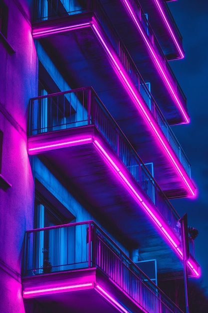 Photo neon lit modern building balconies at night with colorful lighting