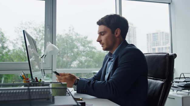 Nervous manager taking call in contemporary glass office handsome employee work