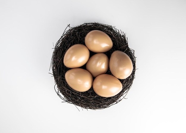 Nest with chicken or bird eggs isolated on a white background top view copy space