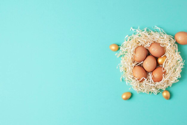 Photo nest with easter eggs with flowers on blue background flat lay copy space