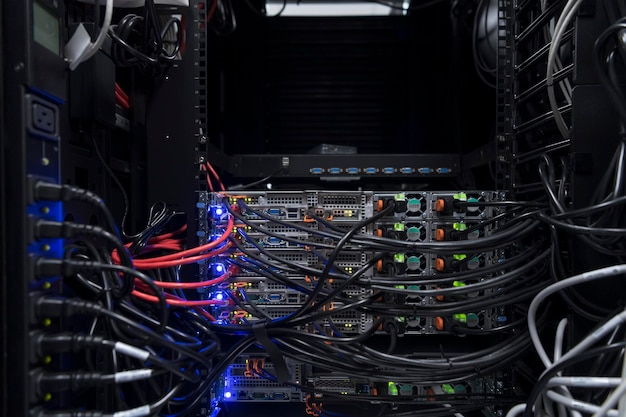 Photo network server room closeup on fiber optic hub or switch for digital communications and internet in mainframe corporate business data center supercomputer