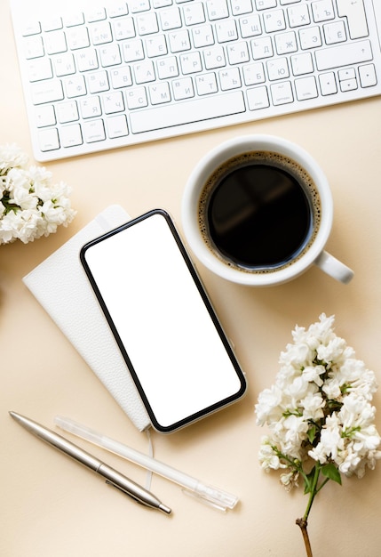 Neutral color tabletop with keyboard lilac flowers and smartpohone mockup with white screen isolated