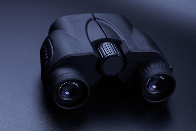 New binoculars isolated on black background Flat lay top view