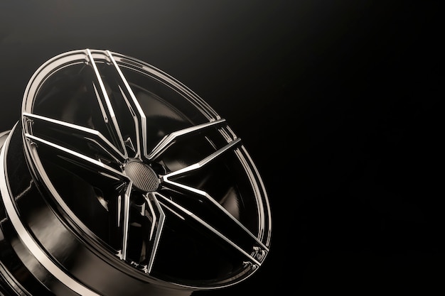 New black shiny alloy wheels rim. light from above, copyspace.