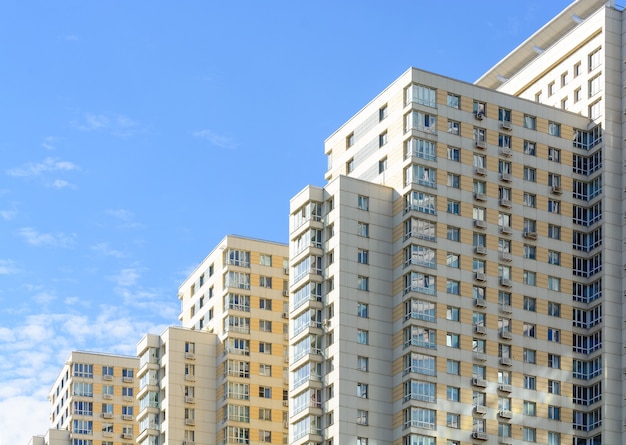 New block of flats buildings on blue sky. Newly built modern apartments.