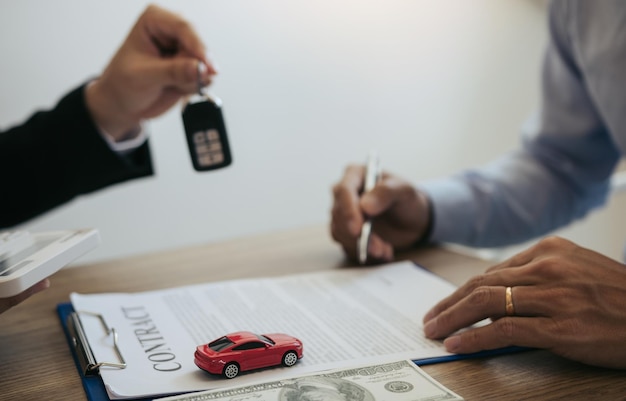 Photo new car buyers sign contract documents for new car purchases at the showroom the salespersons office