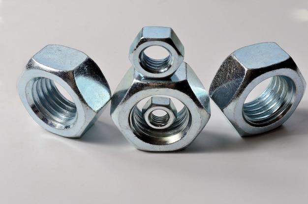 New chrome screw-nut of different sizes on a white.