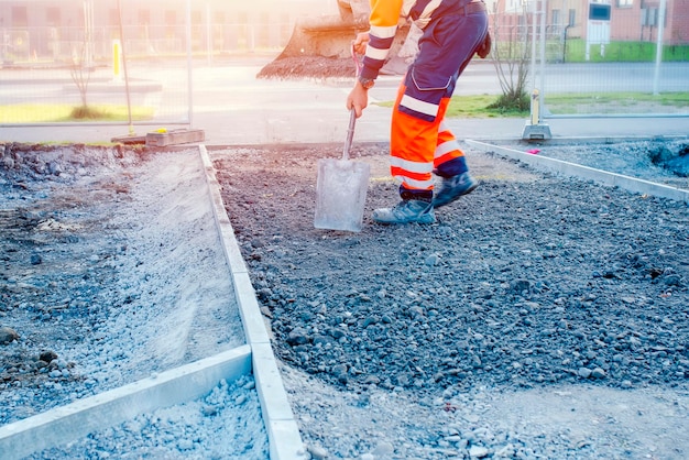 A new footpath is under construction as builders bring stone levelling it and compacting