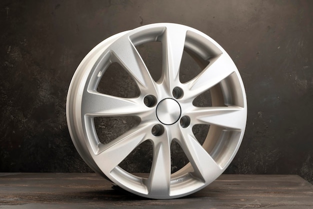 New grey alloy wheels on a dark textured black background a wheel for a car