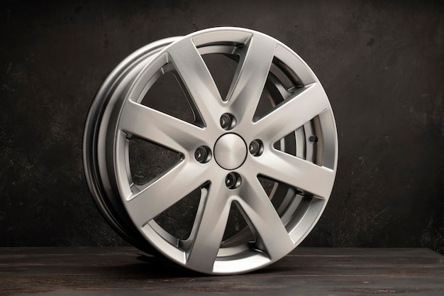 New grey alloy wheels on a dark textured black background a wheel for a car