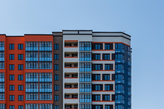 New high rise apartament building with multiple balcony and windows on blue sky with white clouds background